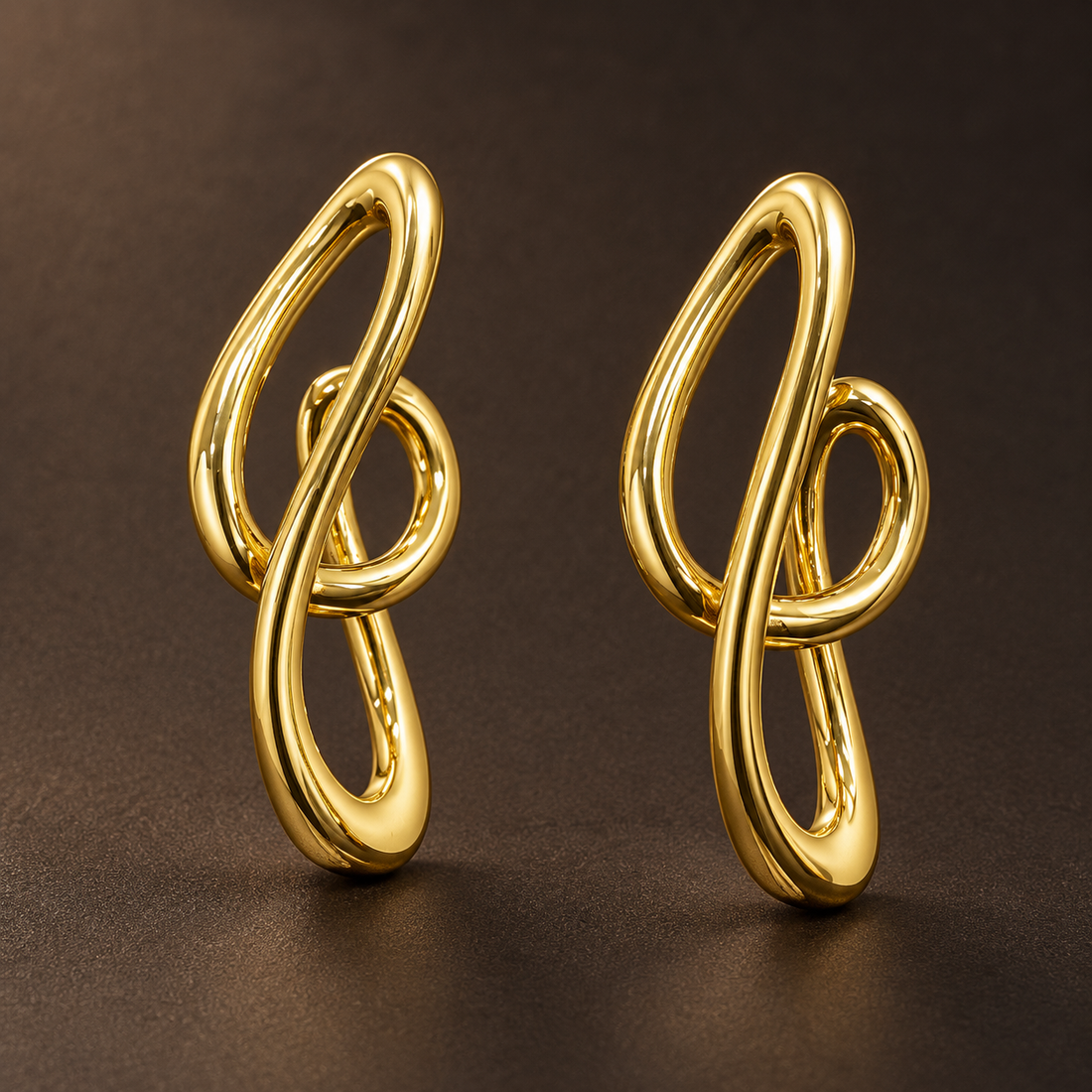 Gold-tone 304 stainless steel earrings in a pair, each a looped knot-shaped wire design with a smooth polished finish, on a dark brown background