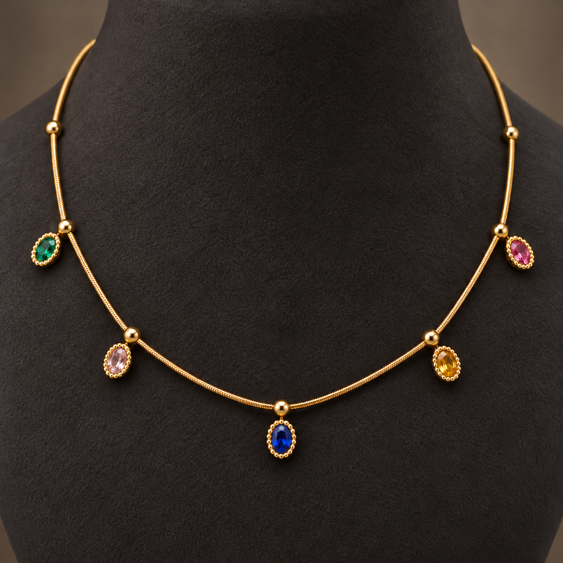 Gold-tone 304 stainless steel necklace with a thin snake chain, gold ball spacers and five oval stones in green, pink, blue, yellow and red, worn on a neck form