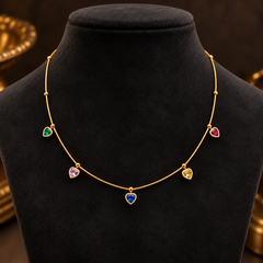 Gold-tone 304 stainless steel necklace with a fine bar chain and five heart-shaped multicoloured stones on bezel settings, displayed on a black bust