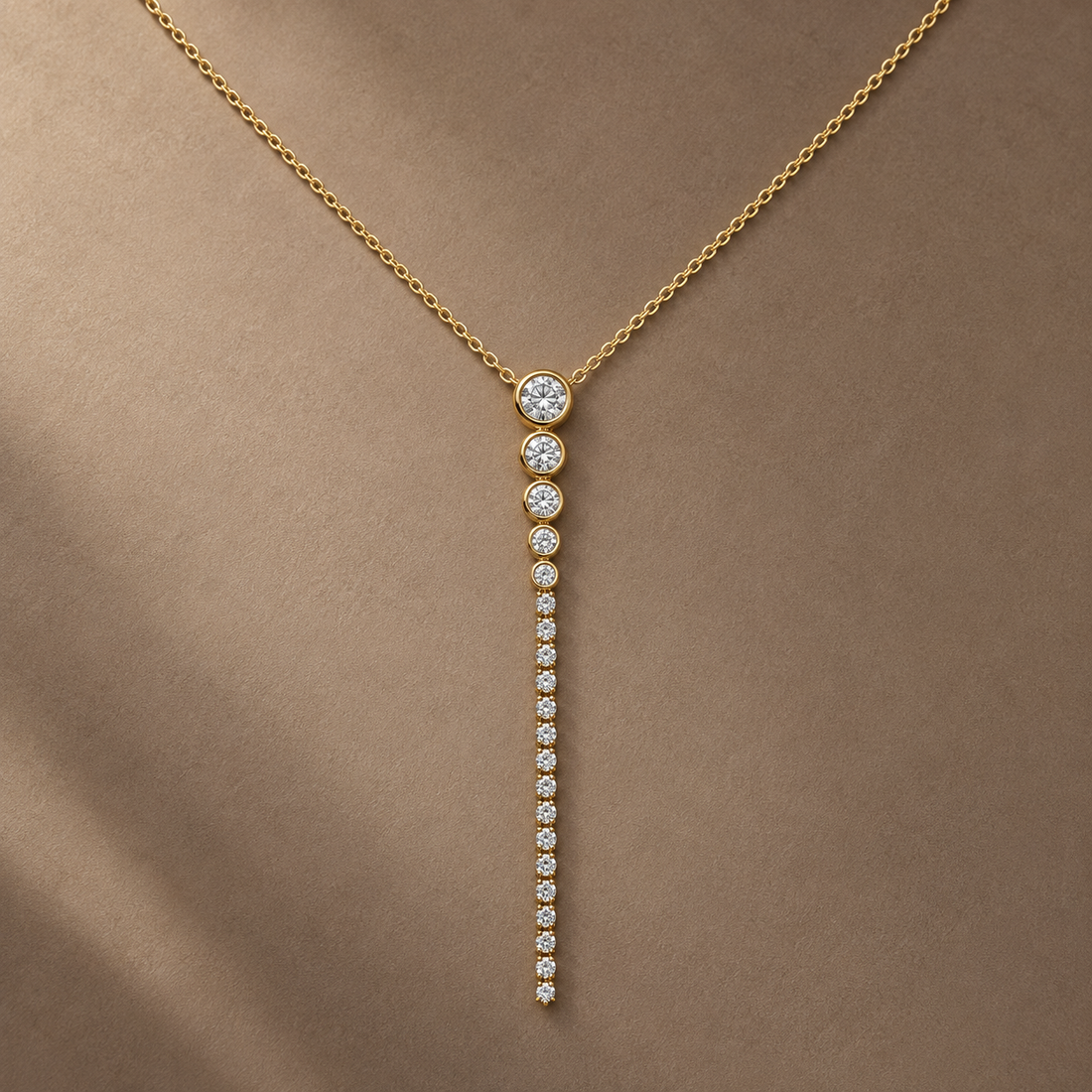 Gold-tone 316L stainless steel necklace with a fine chain and a vertical drop pendant of clear stones graded from large to small, worn on a neck
