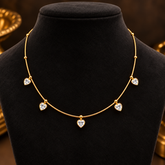Gold-tone 304 stainless steel necklace with a fine snake chain, gold beads and five heart-shaped clear stones hanging from it, shown on a display bust