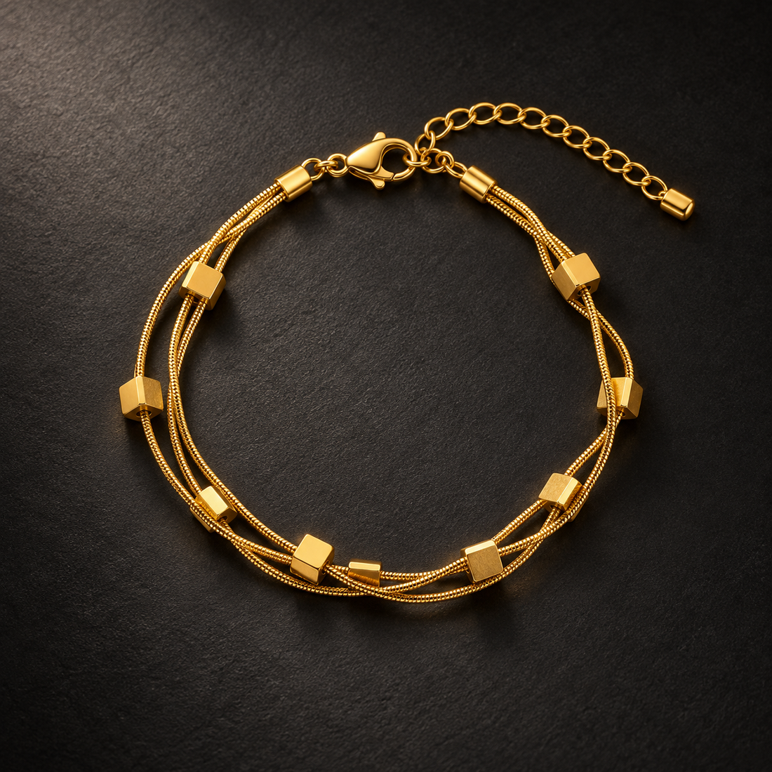 Gold-tone 304 stainless steel bracelet with two thin snake-chain strands and square cube beads, lobster clasp and extender chain, laid flat