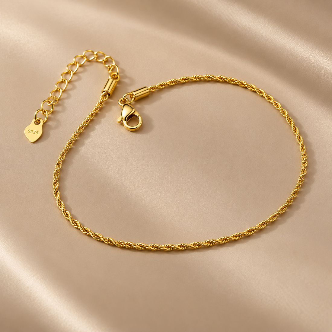 Gold-tone 316L stainless steel rope-chain anklet with a lobster clasp and an extension chain, laid flat on a satin cloth