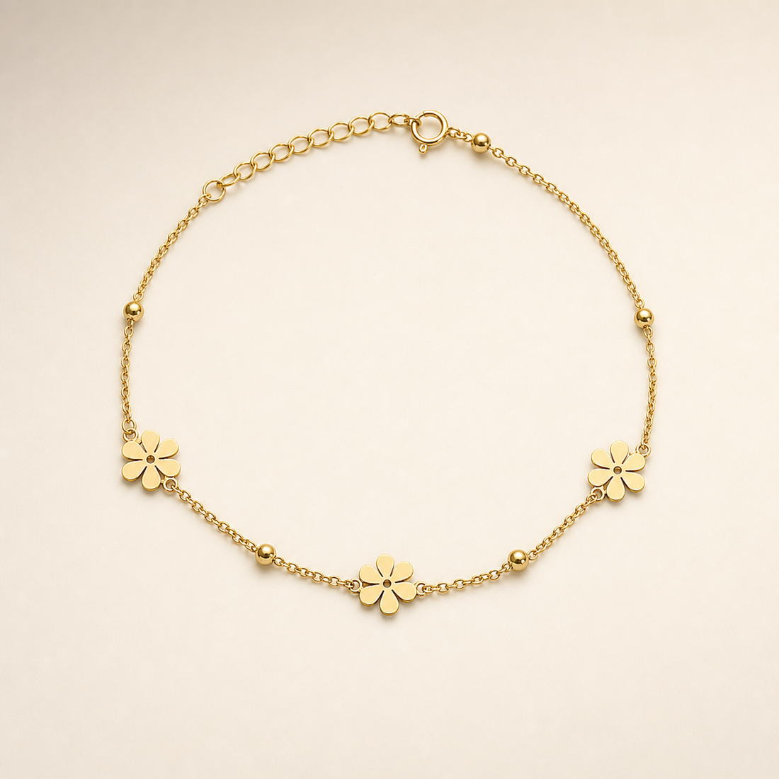 One anklet in yellow-gold-toned metal with a polished finish. Construction is a single strand of fine cable chain in small oval links, with no branches; the full chain run is roughly twenty times the width of the largest component, and the extender, a short section of larger open oval links terminating at the clasp, is about one fifth of the main chain length. A working spring-ring clasp is visible connecting to the extender.