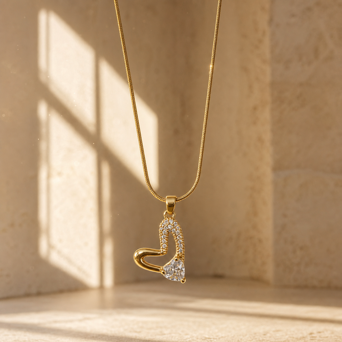 One necklace in yellow-gold-toned metal with a polished finish. It is a single-strand fine-gauge snake chain running continuously to a rectangular slider-style bail from which one pendant hangs. The visible chain run is roughly 25 times the pendant's width; no extender chain is visible in frame, so no extender fraction can be stated, and no working clasp is visible (the chain ends run out of frame).