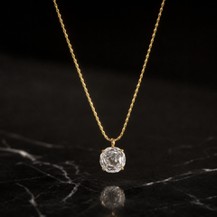 One single-strand pendant necklace in yellow-gold-toned metal with a polished, slightly textured finish. The chain is a single fine, low-gauge twisted/rope-style link chain forming one continuous run; its visible length is roughly 40 to 45 times the width of the pendant, the largest component. No working clasp is visible in the image, and no extender chain or terminal tag is visible; the closure area is partly obscured, so the extender fraction cannot be confirmed.