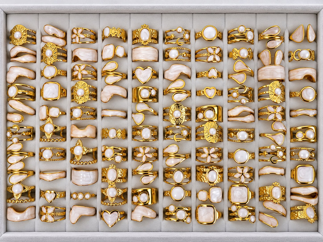 Gold-tone 304 stainless steel rings with pearl-white stones and cream enamel, a mixed set of 50 pieces laid out in a tray