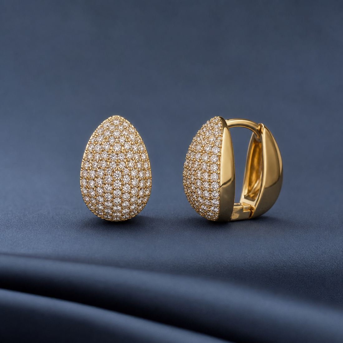 Gold-tone 316L stainless steel huggie earrings with a pavé crystal dome face and a smooth gold-tone hoop, shown as a pair