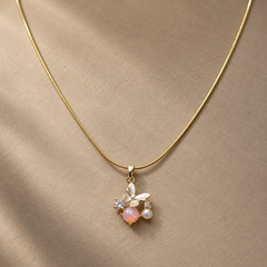 Gold-tone 316L stainless steel snake chain necklace with a butterfly pendant set with an opal-look stone, a pearl and two clear stones, worn on a neck
