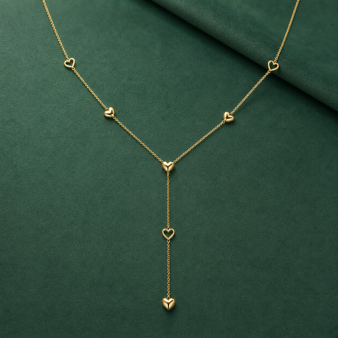 Gold-tone 316L stainless steel lariat necklace with a fine chain and small heart motifs, one pendant heart hanging on a drop chain