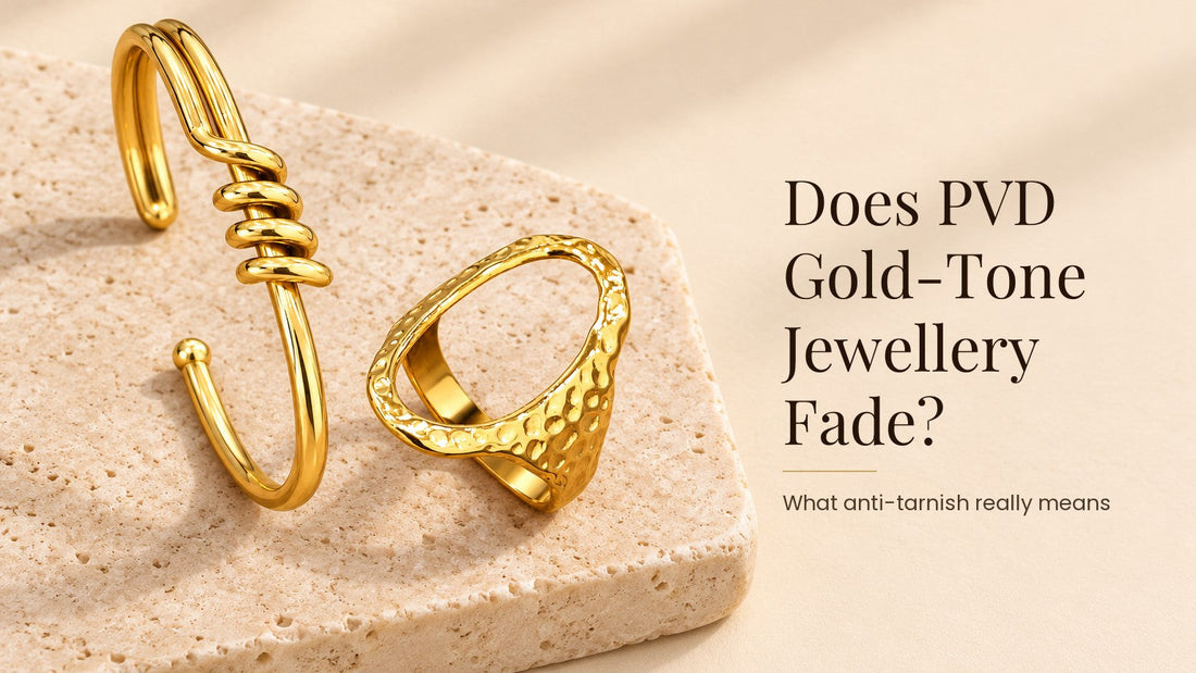 Does PVD Gold-Tone Jewellery Fade?. A glossy gold-tone stainless steel cuff and ring on a pale cream stone slab