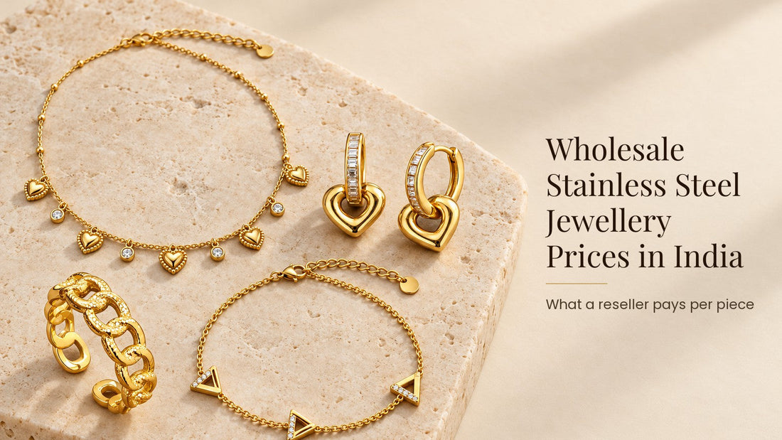 Wholesale Stainless Steel Jewellery Prices in India. Gold-tone stainless steel necklace, earrings, ring and bracelet on a pale cream stone slab