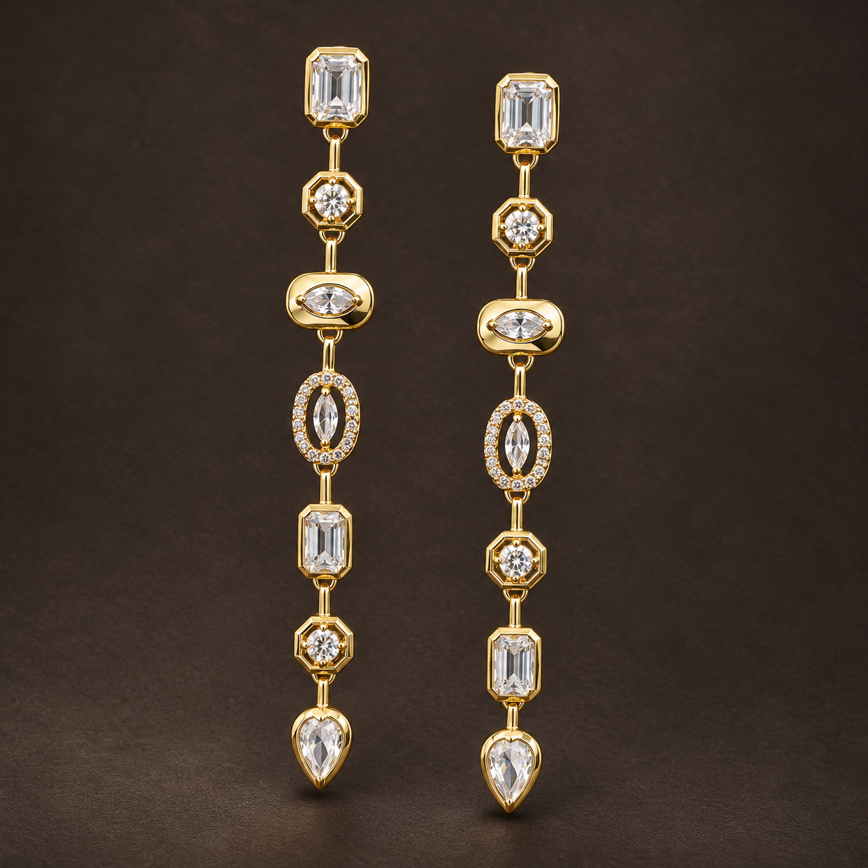 Gold-tone 304 stainless steel drop earrings with a linked row of white crystal stones in emerald, round, marquise and pear cuts