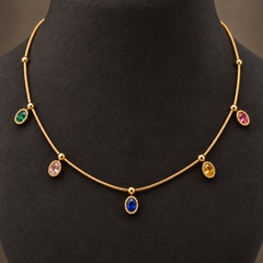 Gold-tone 304 stainless steel necklace with a thin snake chain, gold ball spacers and five oval stones in green, pink, blue, yellow and red, worn on a neck form