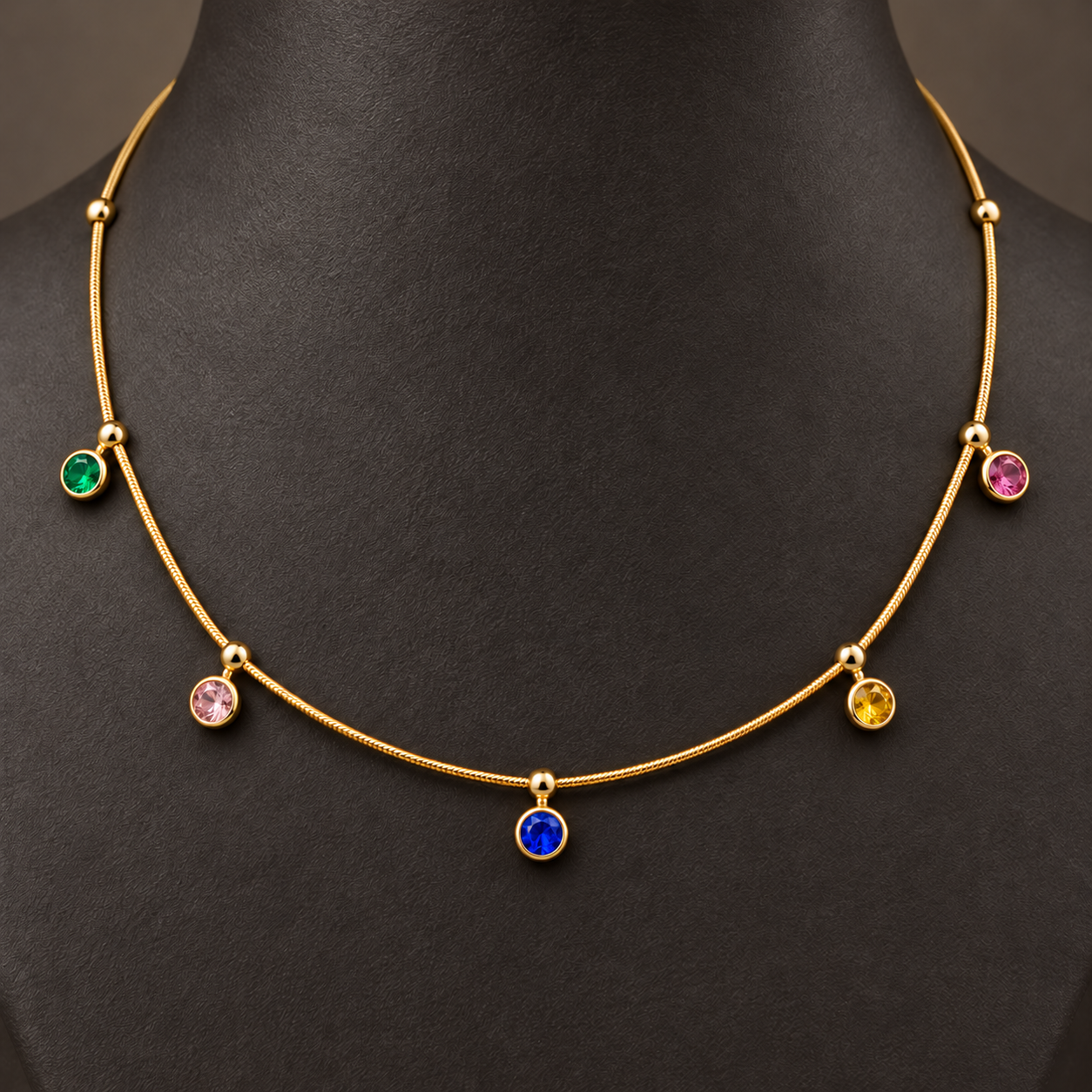 Gold-tone 304 stainless steel necklace with a snake chain and five bezel-set coloured stones on drops, worn on a mannequin neck