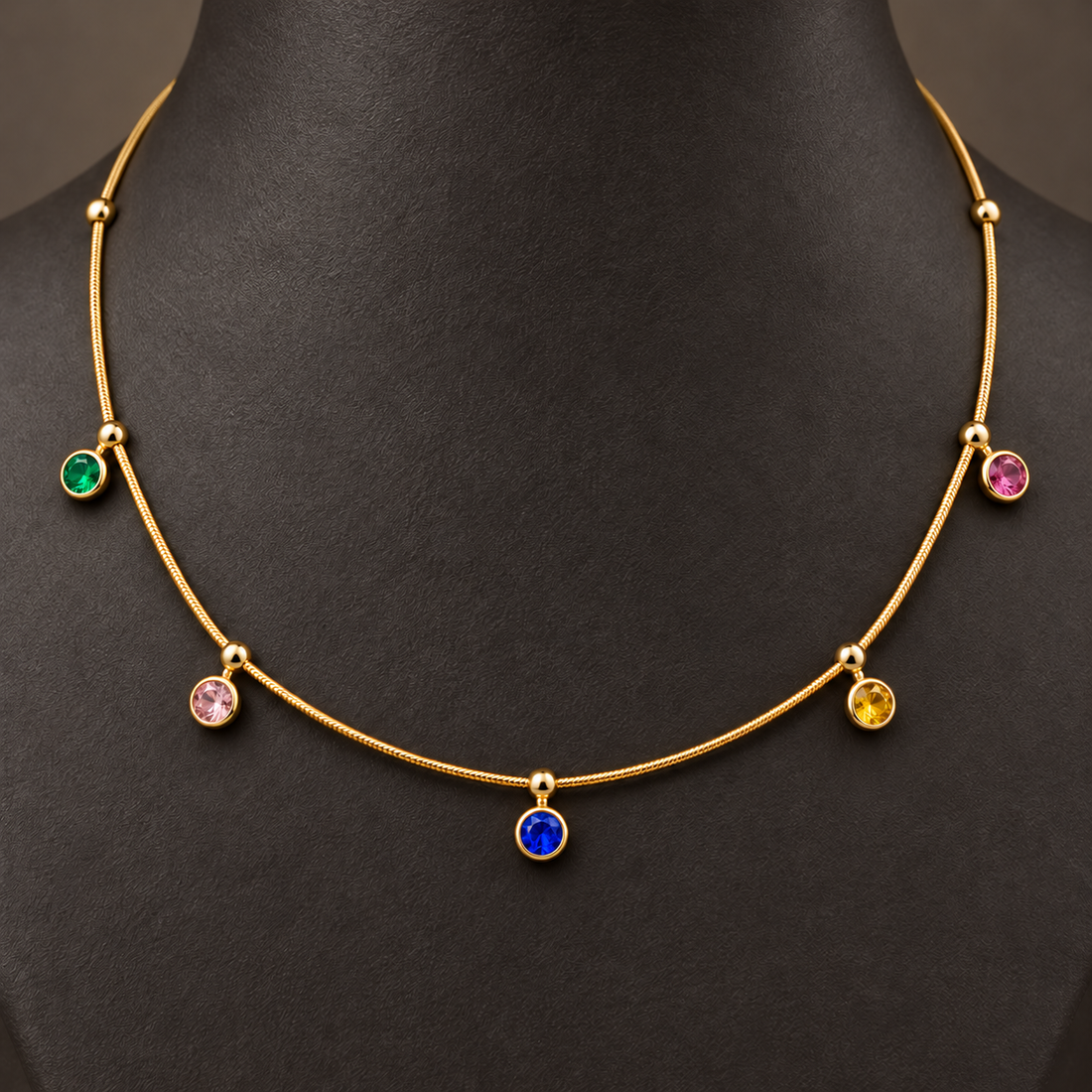 Gold-tone 304 stainless steel necklace with a snake chain and five bezel-set coloured stones on drops, worn on a mannequin neck