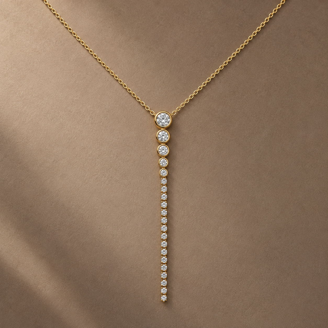 Gold-tone 316L stainless steel necklace with a fine chain and a vertical drop pendant of clear stones graded from large to small, worn on a neck
