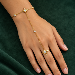 Gold-tone 304 stainless steel hand chain bracelet with starburst motifs, crystal-set links and a ring on the middle finger, worn on a hand