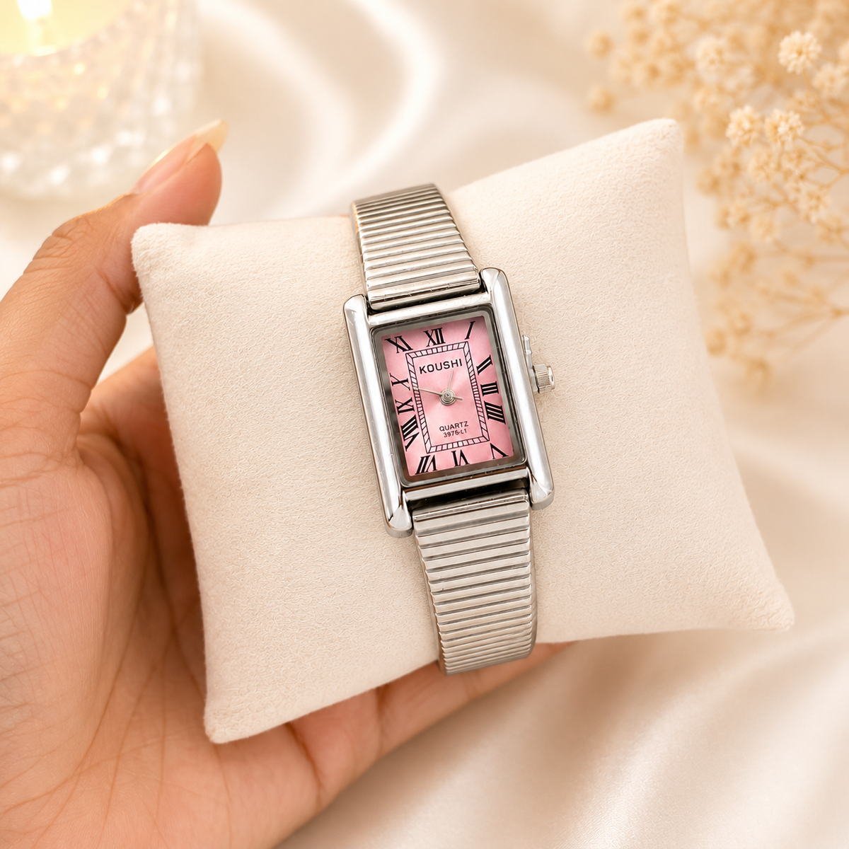 Silver-tone 316L stainless steel rectangular wristwatch with a pink dial, Roman numerals and a ribbed expanding bracelet, worn on a palm