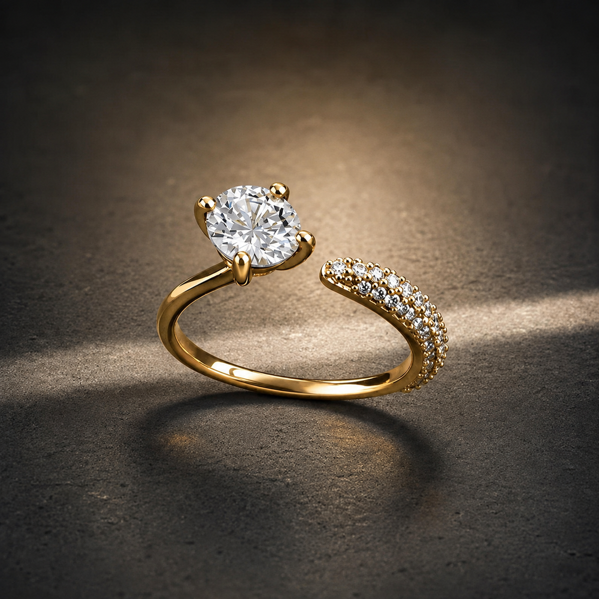Gold-tone 316L open ring with a round stone in a four-prong setting and a pave-set band, shown on a dark surface