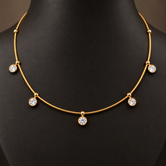 Gold-tone 304 necklace with a thin snake chain and five round clear stones in bezel settings hanging from it, worn on a mannequin neck, close view