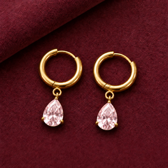 Gold-tone 316L stainless steel hoop earrings with a pear-cut pink crystal drop hanging from each hoop, shown as a pair