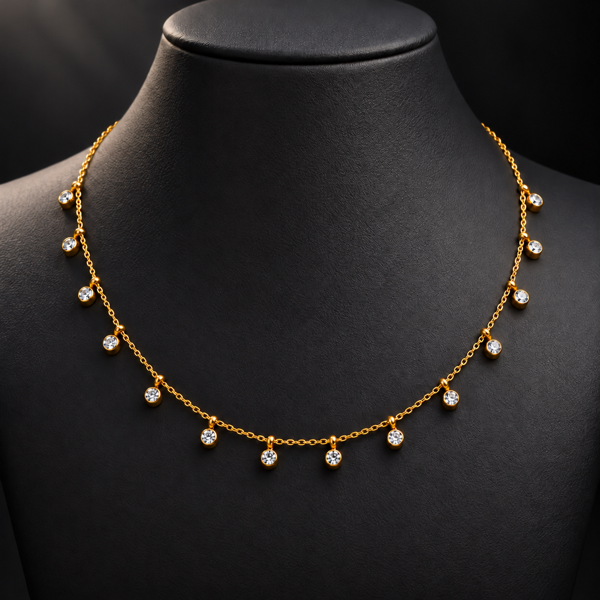 Gold-tone 304 stainless steel necklace with a fine cable chain and round clear stones in bezel settings hanging along the front, shown on a display bust