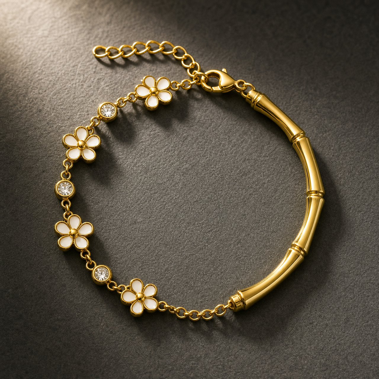 One wrist-worn chain bracelet, gold-coloured metal with a polished finish. Single-strand hybrid construction: one section is a curved rigid bamboo-segmented tube of medium gauge, joined by jump rings to a fine cable-link charm chain of small gauge; the largest component is the bamboo tube. The flexible chain run is approximately twice the bamboo tube's length, and the curb-link extender is roughly one quarter of the main chain. A working lobster clasp is visible.