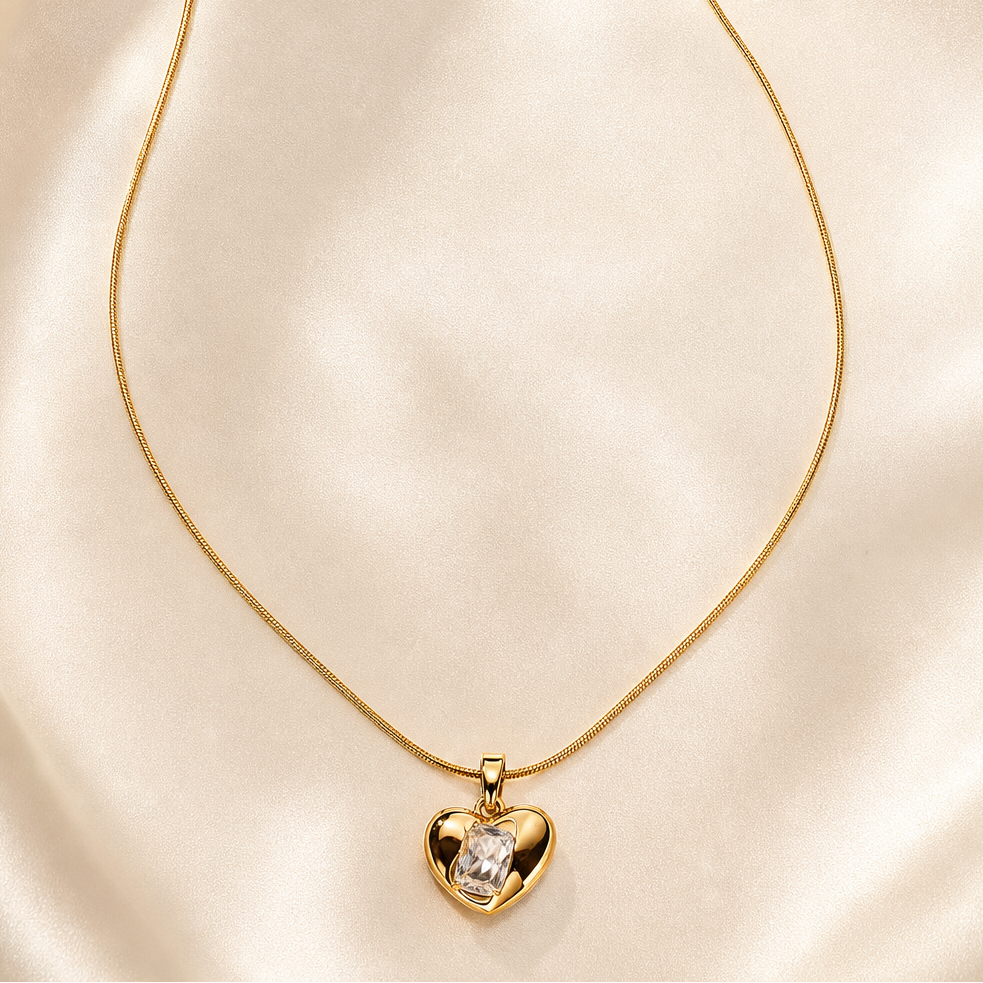 One necklace in yellow-gold-tone metal with a polished finish. It is a single strand of fine, round snake chain of narrow gauge, terminating at one end in a lobster clasp and at the other in a short curb-link extender chain finished with a small elongated bar tag; one extender chain and one terminal tag are present.