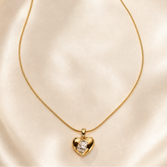One necklace in yellow-gold-tone metal with a polished finish. It is a single strand of fine, round snake chain of narrow gauge, terminating at one end in a lobster clasp and at the other in a short curb-link extender chain finished with a small elongated bar tag; one extender chain and one terminal tag are present.