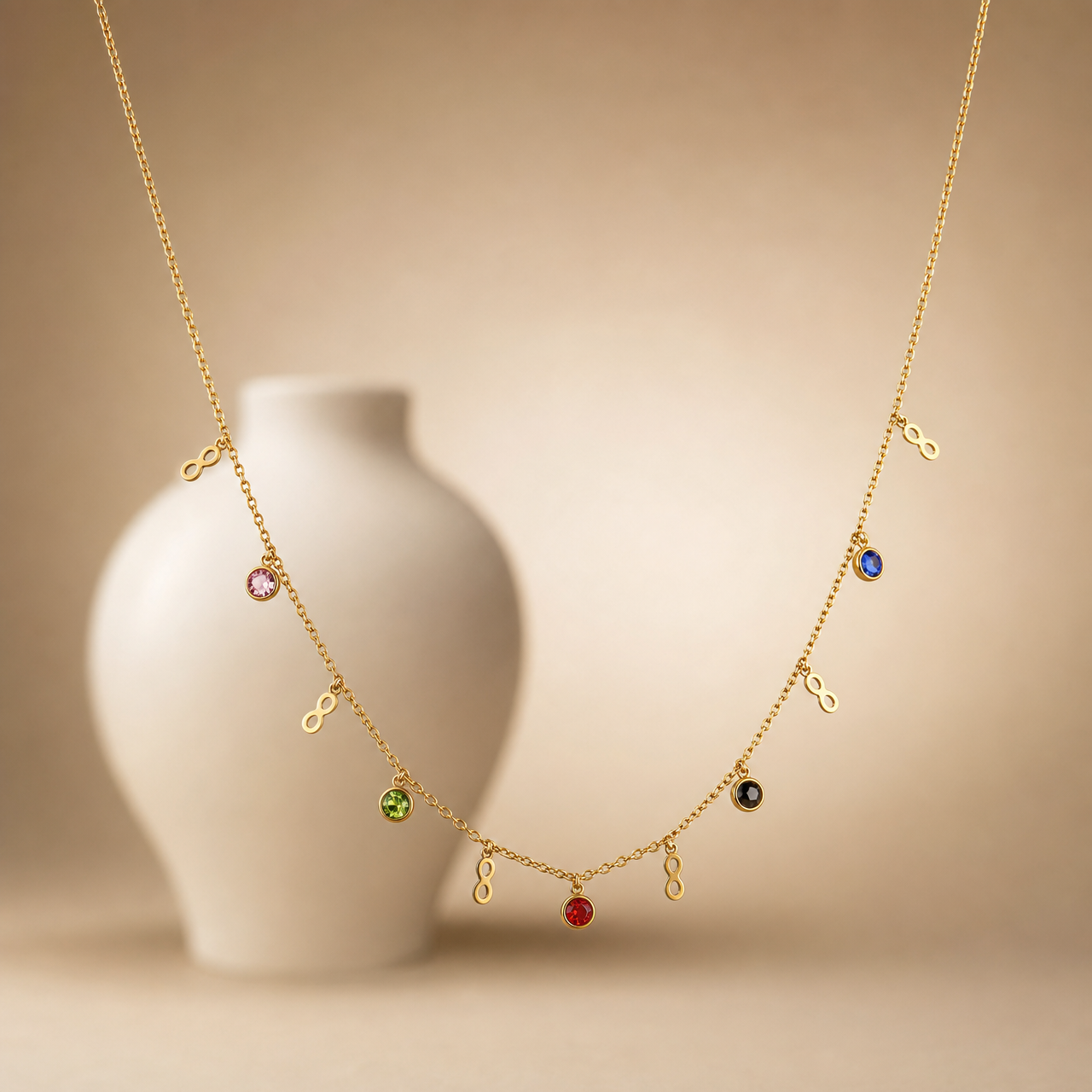 One necklace, a single fine-gauge gold-toned cable chain with polished finish, carrying small dangling stations along its run and no dominant pendant. The chain run is roughly thirty times the width of the largest station; no extender is visible, so no extender fraction can be given, and no working clasp is visible in the image.