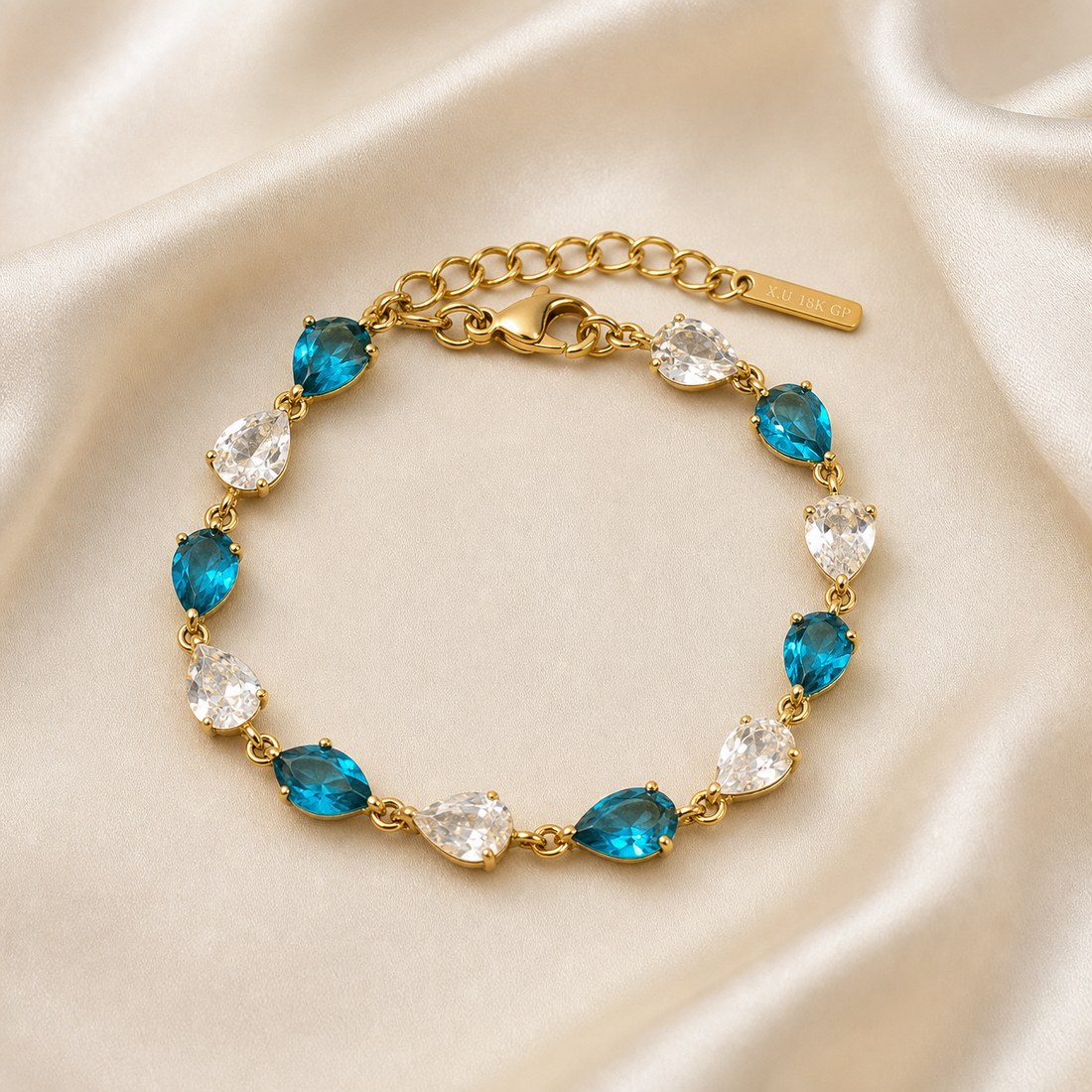 One wrist-worn chain bracelet in yellow-gold-tone metal with a polished finish. It is a single strand of twelve pear-shaped faceted stones, each in a prong setting with pointed end outward, joined by small jump-ring links; there is no separate plain chain run between stones.