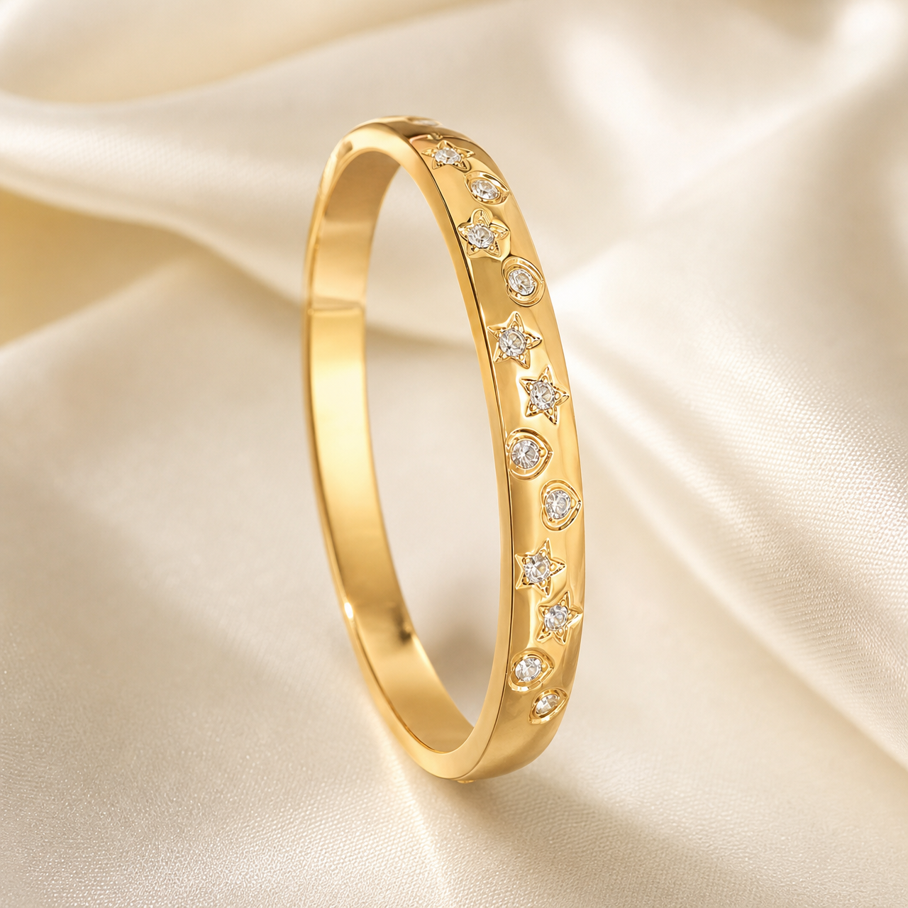 A single rigid oval bangle (kada) in polished yellow-gold-tone metal with a smooth, mirror-finished surface and a solid closed construction of moderately thick, gently rounded band profile. The visible front face carries a repeating decorative scheme of flush, bezel-set clear round faceted stones alternating with engraved star-shaped solid-metal motifs, each star centred with a small clear stone; two motif types are present, a five-pointed star and a circular bezel-set stone, set in sequence along the