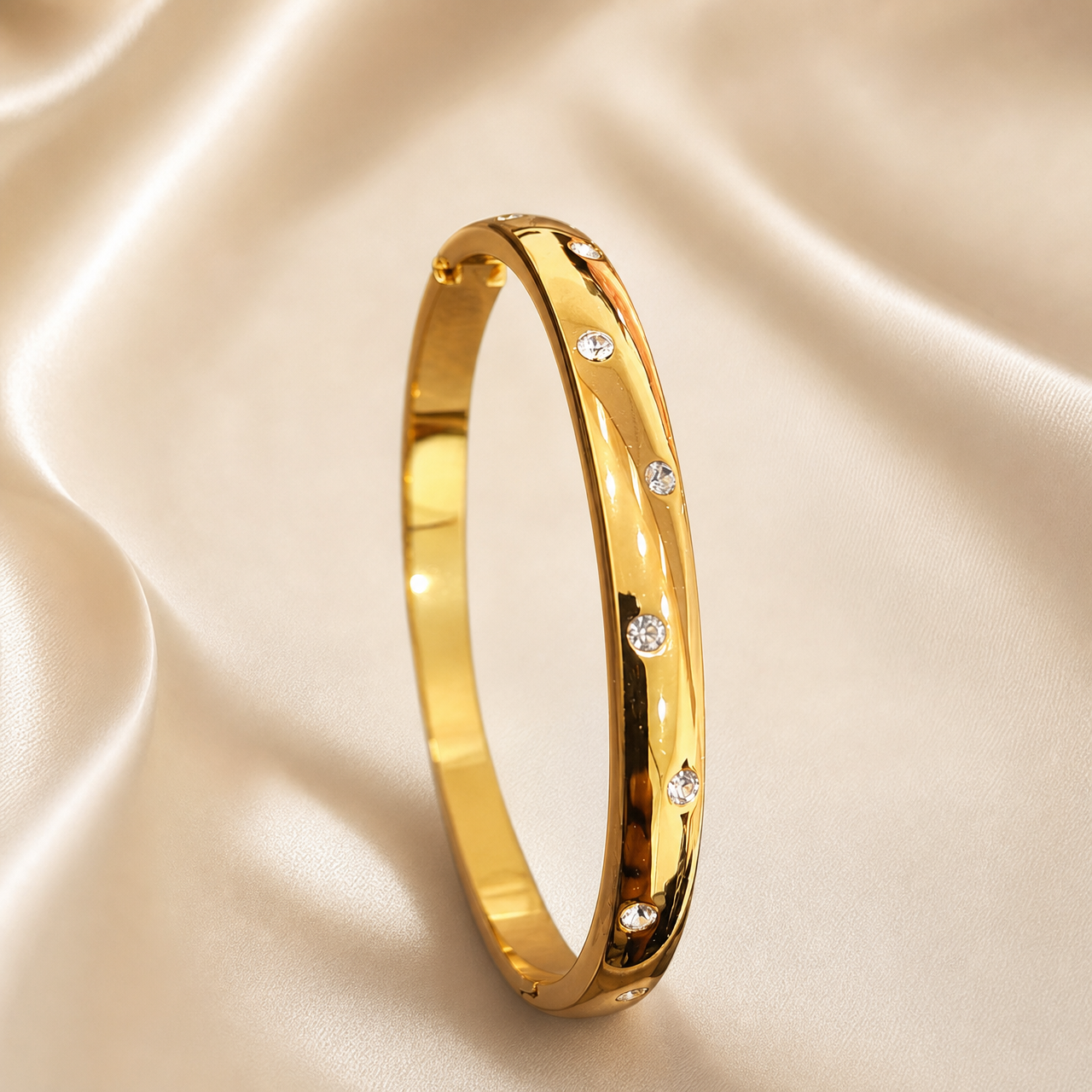 A single rigid oval bangle of yellow gold with a high-polish mirror finish, formed as a continuous solid band of medium gauge with a softly domed outer profile and flat inner surface. Set into the outer face are round, clear, colourless faceted stones in flush (gypsy) settings, each sitting level with the metal surface in its own small circular seat; the stones are of similar small size and are distributed at irregular, uneven intervals around the visible face rather than in an even grid, with some
