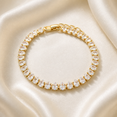 One wrist-worn chain bracelet. Yellow-gold-tone metal with a polished finish. Construction is a single flexible stone-set strand: fine-gauge articulated tennis-style links connect individual basket settings end to end, with no branches. The stone-set run is approximately 30–35 times the width of the largest pear element; the short plain terminal/adjuster section is about one-twentieth of the main run.