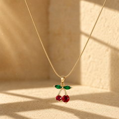 One necklace-pendant: a single gold-tone polished fine snake-chain strand with a compact round gauge, connected by a small jump ring to a solid-metal bail and one cherry-cluster pendant. The visible chain run is approximately twenty times the widest pendant measurement; no extender is visible, so the extender fraction is effectively none/not resolved, and no working clasp or terminal tag is visible.