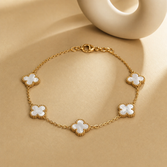 One wrist-worn chain bracelet in yellow-gold-tone metal with a polished finish. It is a single-strand fine oval-link cable chain of small gauge carrying five four-lobed clover motifs set in-line as stations along the strand. Each motif is a flat white iridescent inlay, roughly equal in size, framed by a beaded-edge gold bezel and integrated into the chain at two opposite lobes.