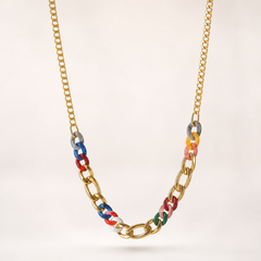 One necklace, gold-tone metal with a polished finish. Single-strand construction: a fine-gauge curb chain forms the long rear run, transitioning at each side into a short section of chunky, large-gauge curb links interspersed with glossy coloured resin links; the chain is continuous with no branches or drops. The full chain run is roughly 25 times the width of the largest chunky link; a short extender chain, about one eighth of the main run, ends in a single slim bar terminal tag.