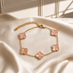 One chain bracelet in yellow-gold-tone metal with a polished finish, built as a single strand of fine cable chain in a small oval-link gauge, punctuated by five four-lobed clover (quatrefoil) motifs as inline stations. The chain run is approximately 13 times the width of the largest motif, and the extender is roughly one third of the main chain length. A working lobster-claw clasp is visible at one end.