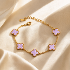 One wrist-worn chain bracelet. Yellow-gold-coloured metal with a polished finish. Single-strand construction of fine-gauge oval cable chain, with no branching; five matching quatrefoil clover stations are set inline along the strand, linked by short chain intervals and joined end-to-end into one continuous run. The clasp-to-far-end chain run is approximately eleven times the width of the largest clover component; the extender is roughly one half the length of the main chain.