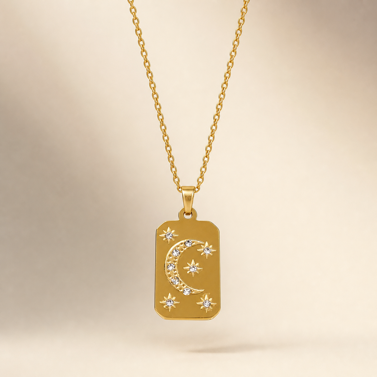 One necklace in yellow-gold-toned metal with a polished finish. A single fine twisted rope chain, small-gauge links, connects at both ends to a solid tapered bail, which suspends one dominant rectangular tag pendant with rounded corners and a small loop at its top. The chain run is approximately 15-20 times the pendant's width; the clasp and any extender are not visible in the frame, so closure type is unresolved and no extender or terminal tag is seen.