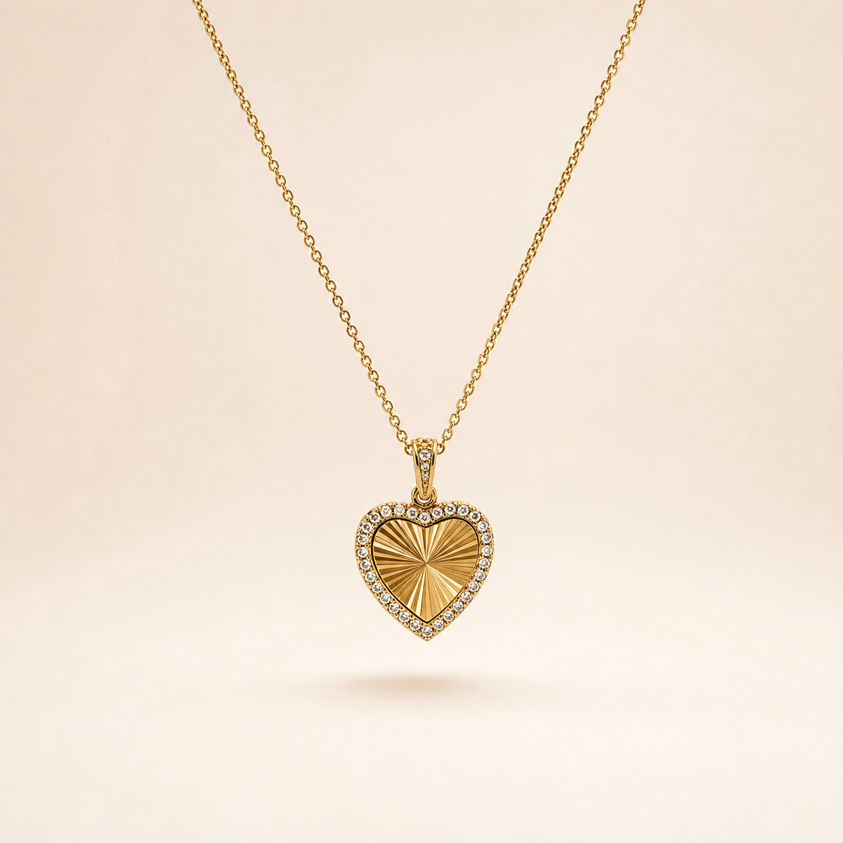 A single yellow gold-tone necklace with a polished finish, comprising one continuous fine-gauge cable-chain strand with small oval links and a single pendant drop. The chain run is approximately 25 times the width of the pendant. The clasp end and any extender are partly obscured; no working closure or terminal tag is visible in what can be seen, so no extender fraction can be stated.