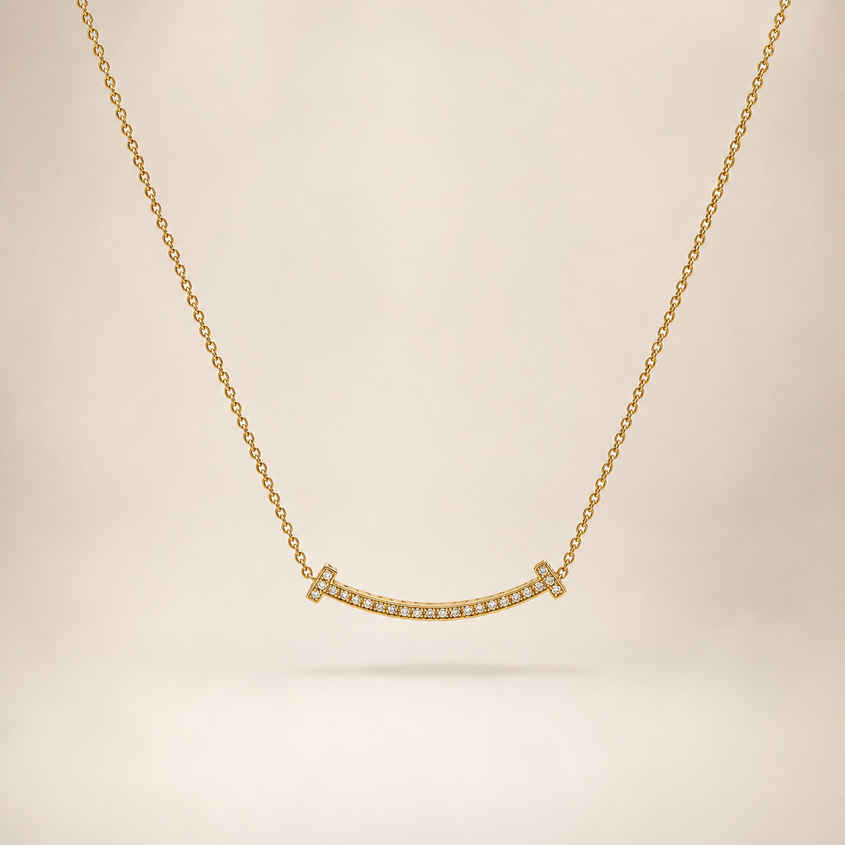 One necklace in yellow-gold-tone metal with a polished finish. It is a single strand of fine, small-gauge cable chain running continuously from a clasp at one end around to the far end; the chain run is approximately 10 to 12 times the width of the largest component, the central curved bar. No extender chain is visible, so no extender-to-main-chain fraction can be stated; a working clasp is present but its mechanism is partly obscured at the rear of the strand.