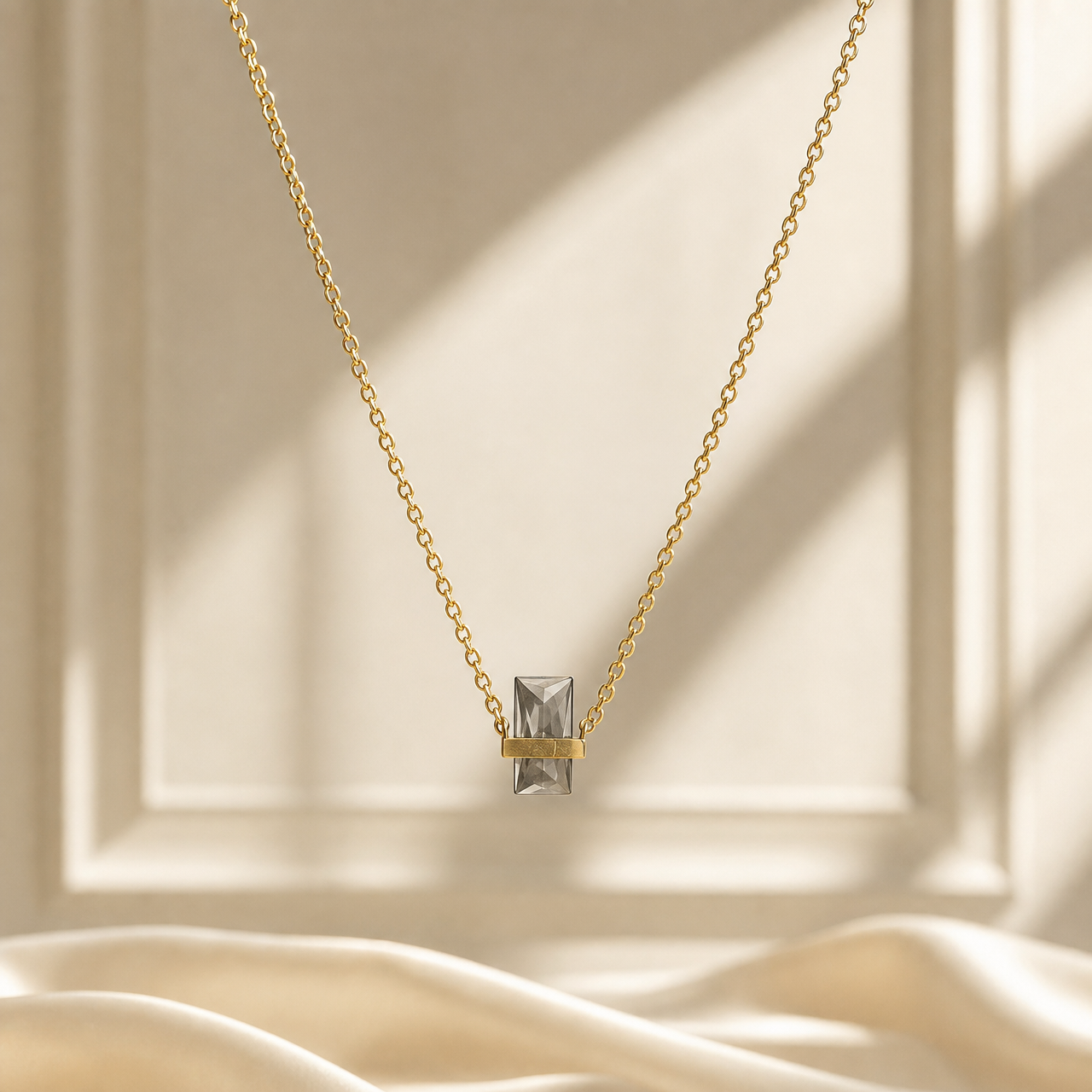One single-strand necklace in yellow-gold-toned metal with a polished finish. The chain is a fine cable chain of small oval links of light gauge, forming one continuous strand with no branches. Its full chain run measures roughly 80 to 90 times the width of the largest component; no extender chain is visible, so no extender fraction can be stated, and no working closure is visible as the rear of the strand is partly obscured.