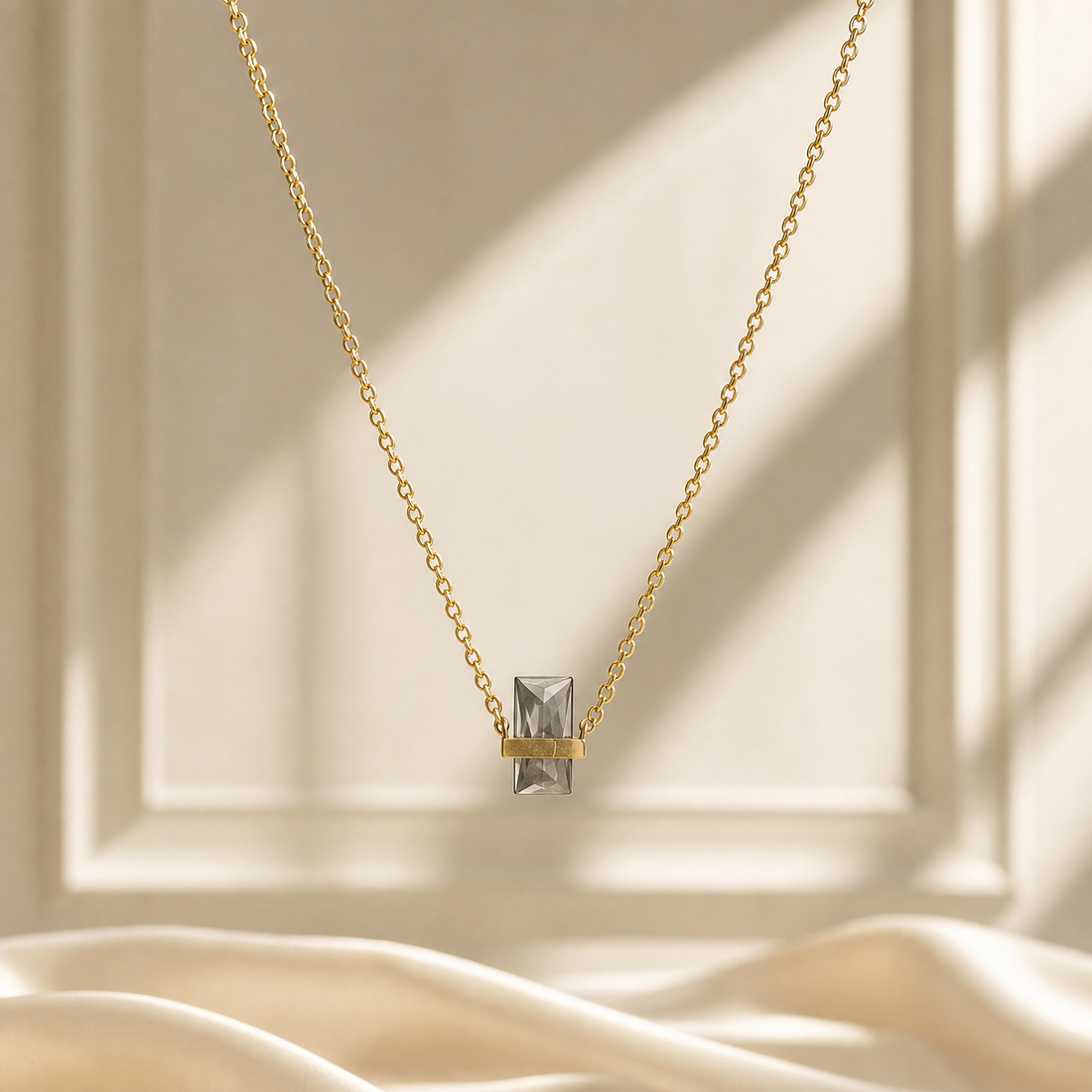 One single-strand necklace in yellow-gold-toned metal with a polished finish. The chain is a fine cable chain of small oval links of light gauge, forming one continuous strand with no branches. Its full chain run measures roughly 80 to 90 times the width of the largest component; no extender chain is visible, so no extender fraction can be stated, and no working closure is visible as the rear of the strand is partly obscured.