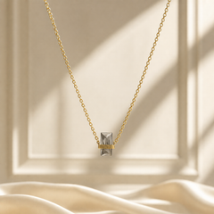 One single-strand necklace in yellow-gold-toned metal with a polished finish. The chain is a fine cable chain of small oval links of light gauge, forming one continuous strand with no branches. Its full chain run measures roughly 80 to 90 times the width of the largest component; no extender chain is visible, so no extender fraction can be stated, and no working closure is visible as the rear of the strand is partly obscured.