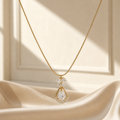 A single necklace with one dominant pendant. Yellow-gold metal with a polished finish. Construction is a single strand of very fine, tight snake-style chain of narrow gauge; the chain run measures roughly 40 times the width of the largest pendant element. The closure is not visible in the image and no extender chain or terminal tag is resolvable.