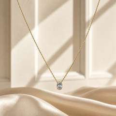 One necklace with a single dominant pendant. The metal is yellow-gold toned with a polished finish. Construction is a single fine strand of small-gauge cable (trace) chain forming one continuous run with no branches; the chain run is roughly 60 to 70 times the width of the pendant, which is the largest component.