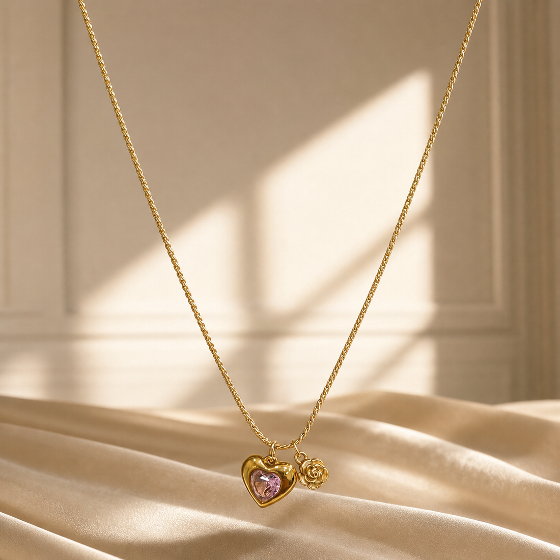 One necklace in yellow-gold-toned metal with a polished finish. It is a single strand of fine, tight woven foxtail-style chain of small gauge, its total run roughly 30 to 35 times the width of the largest component, the heart pendant; no extender chain is visible. The clasp is not visible in the image and the rear of the strand is partly obscured.