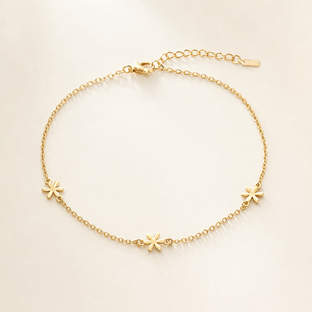 One anklet in yellow-gold-toned metal with a bright polished finish. It is a single-strand fine cable chain of small uniform oval links, unbroken except for three solid-metal star-shaped station charms spaced along it. The full chain run is approximately 30 times the width of the largest star charm, ankle length.
